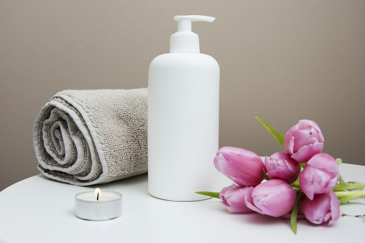 Illustrative spa still life with a towel, candle, and flowers